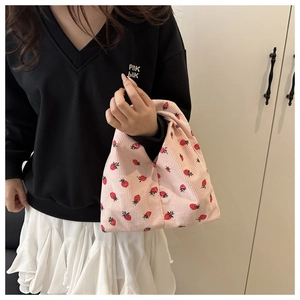 Détail d'un sac à main en velours côtelé rose avec imprimé fraise et anse unique