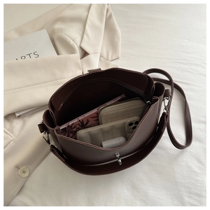 Internal view of dark brown bucket bag showing large capacity for laptop and wallet