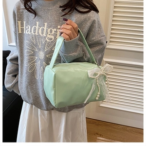 Detail of light green mini square bag with lace pearl bow charm and soft PU leather