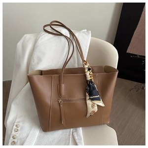 Brown leather tote bag featuring a decorative patterned silk scarf and side zip pocket