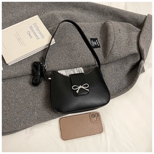 Détail du sac hobo en cuir noir avec boucle de nœud en métal argenté et forme en croissant
