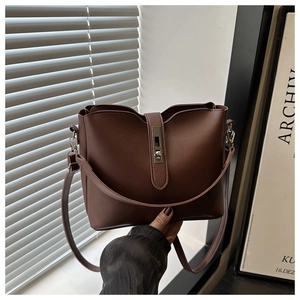 Detail of dark brown leather bucket bag with silver twist lock and minimalist design
