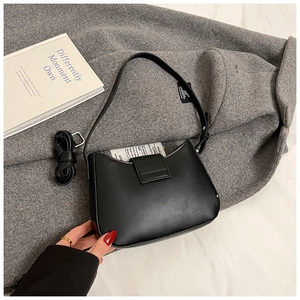Gros plan du sac hobo noir mat sur un manteau en laine avec bandoulière réglable