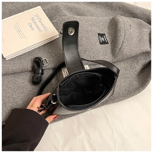 Détails de l'intérieur du sac à bandoulière noir avec matériel argenté et poche zippée