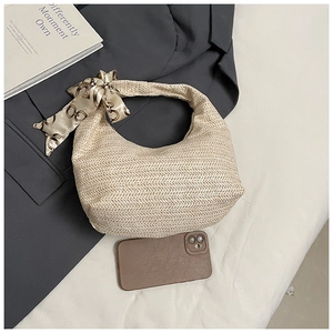 Detail of beige crescent woven handbag with elegant brown chain print silk scarf accessory