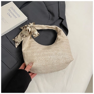 Detail of beige woven straw shoulder bag with chain-pattern silk scarf handle decoration