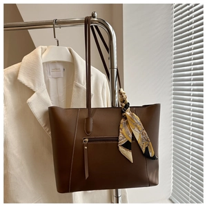 Detail of dark brown tote bag with silk scarf and functional back zipper pocket