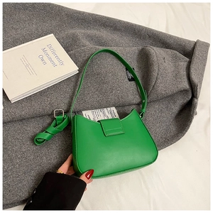Détail du sac sous le bras vert avec deux bandoulières interchangeables et finitions en métal