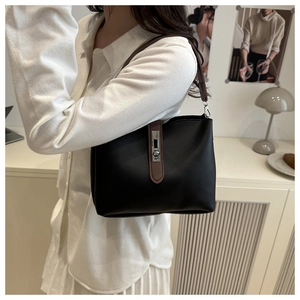 Détail du sac seau rétro en cuir noir avec fermoir tournant en métal et bandoulière