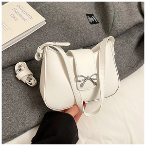 Detail view of white hobo bag with silver bow buckle and detachable shoulder strap