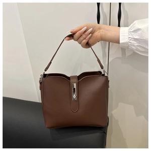 Detail view of dark brown pebbled leather bucket bag with silver rectangular twist lock