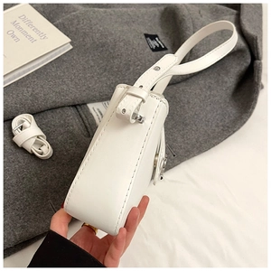 Détail du sac à bandoulière en cuir blanc avec texture fine et sangle amovible