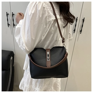 Detail view of the silver rectangular metal buckle on a classic black bucket bag
