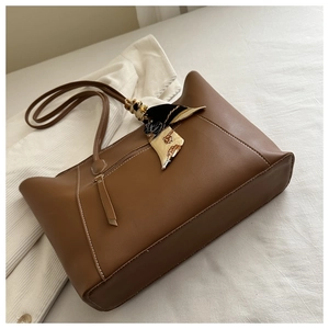 Detail of caramel faux leather tote bag with zip pocket and decorative vintage scarf