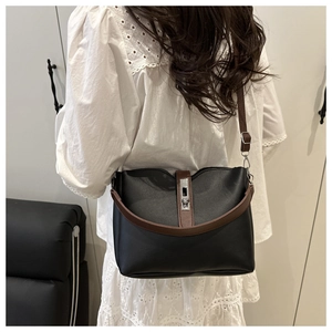 Detail view of the two-tone bucket bag with silver metal twist lock on black leather