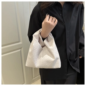 Detail of cream woven shoulder bag featuring intricate faux leather grid pattern