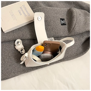Capacité interne du sac demi-lune en cuir blanc montrant les accessoires du quotidien
