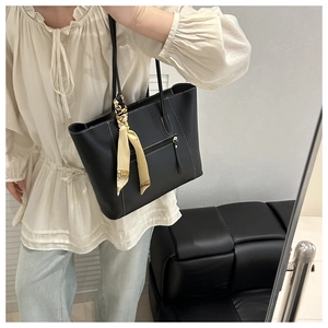 Detail of black tote bag with white contrast stitching and printed silk scarf on handle