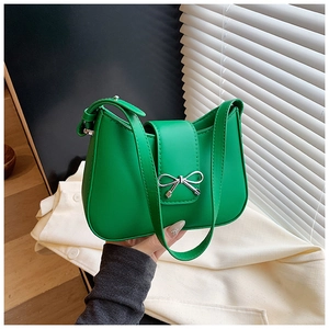 Détail d'un sac à bandoulière en cuir PU vert avec noeud argenté et rabat