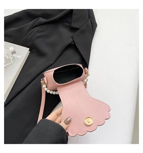 Detail of pink shell-shaped mini bag with large pearl handle and magnetic closure