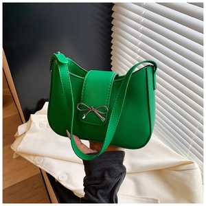 Détail d'un mini sac sous le bras vert vif doté d'une boucle nœud en métal argenté