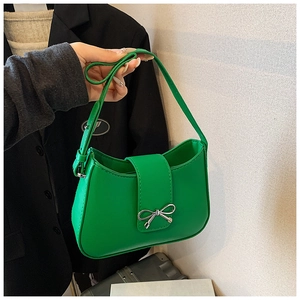 Vue détaillée du sac vert vif avec un fermoir décoratif en forme de nœud en métal argenté
