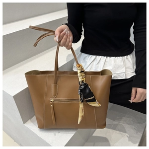 Brown tote bag detail with decorative printed silk scarf and zippered front pocket