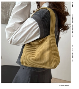 Detail of vintage corduroy texture on mustard yellow tote bag with minimalist strap