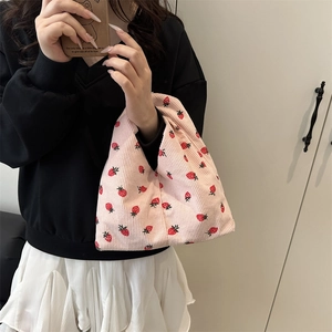 Sac à main en velours côtelé rose avec motif fraise dans un cadre de vie décontracté