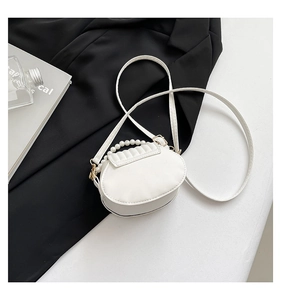 Detail of white half-round shell purse with pearl handle and pleated faux leather design