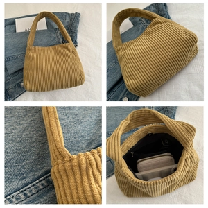 Detail view of mustard yellow corduroy shoulder bag with magnetic snap and interior storage