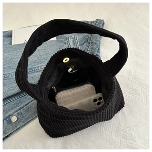 Internal view of black corduroy tote bag showing large capacity with magnetic snap button