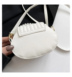 Detail of white PU leather shell bag with pearl handle and quilted pattern design