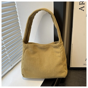 Close-up of yellow corduroy shoulder bag showing vertical rib texture and soft fabric