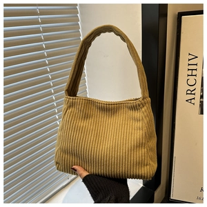 Close-up of mustard yellow corduroy shoulder bag showing premium texture and strap
