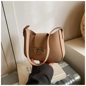 Détail du sac beige vintage avec boucle en forme de nœud et texture de cuir lisse