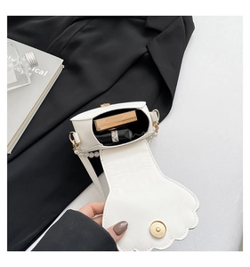 Detail view of the pearl chain shell bag interior showing storage for cosmetics