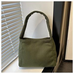 Macro detail of military green corduroy fabric texture on a minimalist shoulder bag