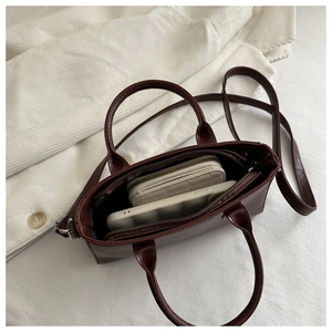 Internal view showing capacity of chocolate brown square handbag with main compartment