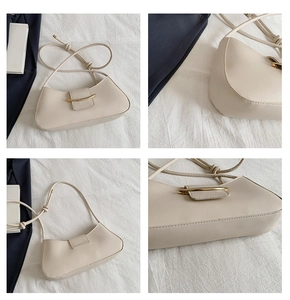 Detail of beige crescent underarm bag with gold metal buckle and knotted rope shoulder strap