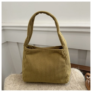 Detail shot of mustard yellow corduroy shoulder bag showing soft ribbed texture fabric