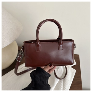 Detail of vintage square handbag in brown faux leather with Fashion embossed text