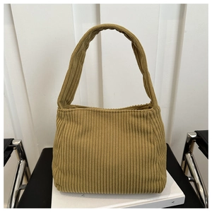 Detail of solid color corduroy tote bag showing soft ribbed texture on modern chair