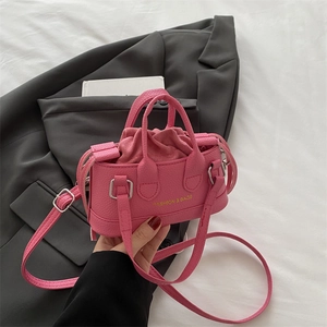 Pink lychee leather mini shell bag with drawstring liner and crossbody strap