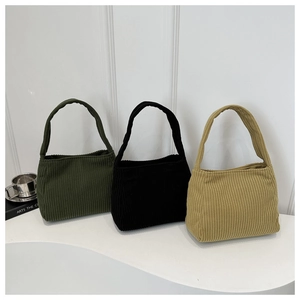 Detail of corduroy tote bags showing vertical ribbed texture in dark green, black and khaki