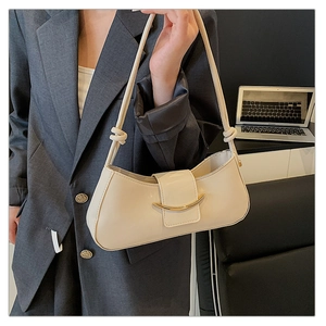 Chic cream half-moon underarm bag with gold metal buckle and knotted strap on model