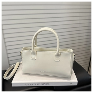 Detail of a cream white PU leather handbag with FASHION text and fine stitching accents