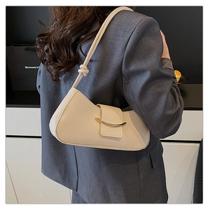 Detail of a creamy beige leather crossbody bag featuring a unique knotted shoulder strap