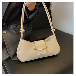 Detail view of cream white leather shoulder bag featuring a crescent gold metal buckle