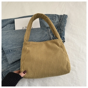 Close-up of khaki corduroy shoulder bag showing vertical ribbed texture and minimalist style